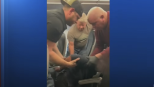 Frontier Airline Passenger Allegedly Kicks Plane Window, Restrained by Other Passengers. Credit ABC13 Houston